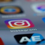 Instagram app icon in focus on a smartphone screen, blurred background.